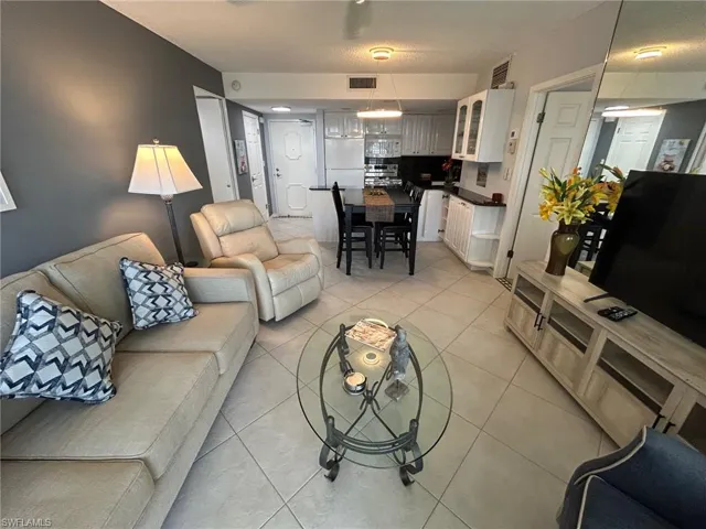 Living room with light tile patterned floors and a textured ceiling