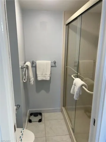 Full bathroom with a stall shower and light tile patterned floors