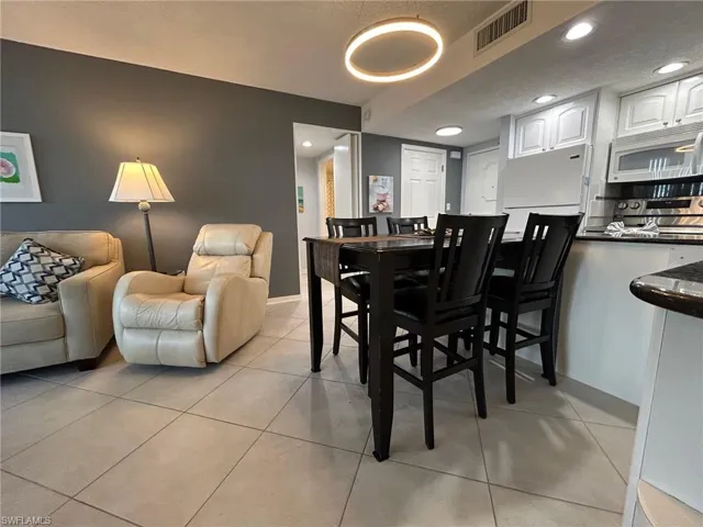 Dining room with recessed lighting, light tile patterned floors, and a textured ceiling