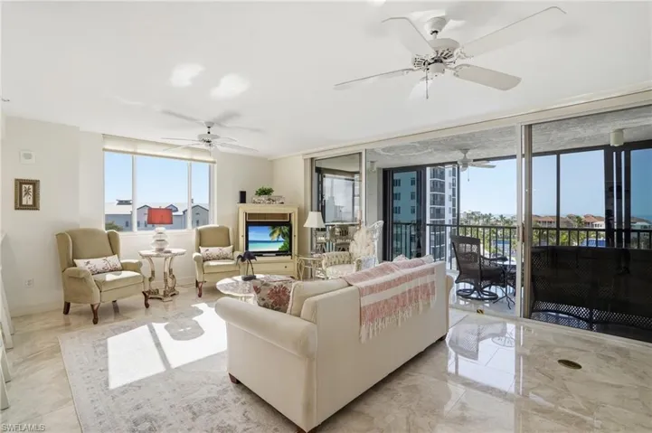 Living room featuring expansive windows and a ceiling fan - Virtually Edited Image