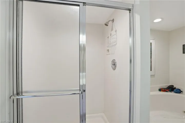 Full bathroom featuring a shower stall and a bath - Virtually Edited Image