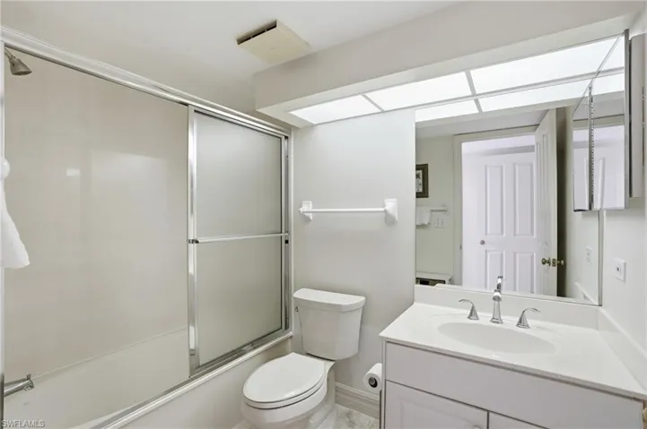 Bathroom featuring vanity and enclosed tub / shower combo - Virtually Edited Image