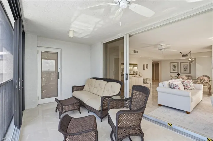Sunroom with outdoor seating, a ceiling fan, and suspended lighting - Virtually Edited Image