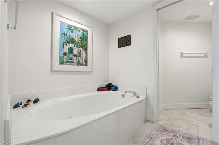 Full bathroom featuring a bath and toilet - Virtually Edited Image