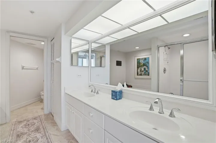 Bathroom featuring double vanity, a stall shower, and recessed lighting - Virtually Edited Image