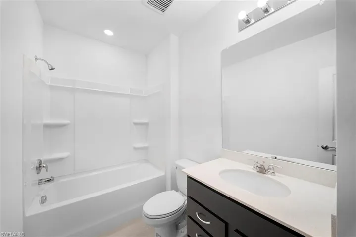 Full bath with vanity,  shower combination, and light tile patterned floors