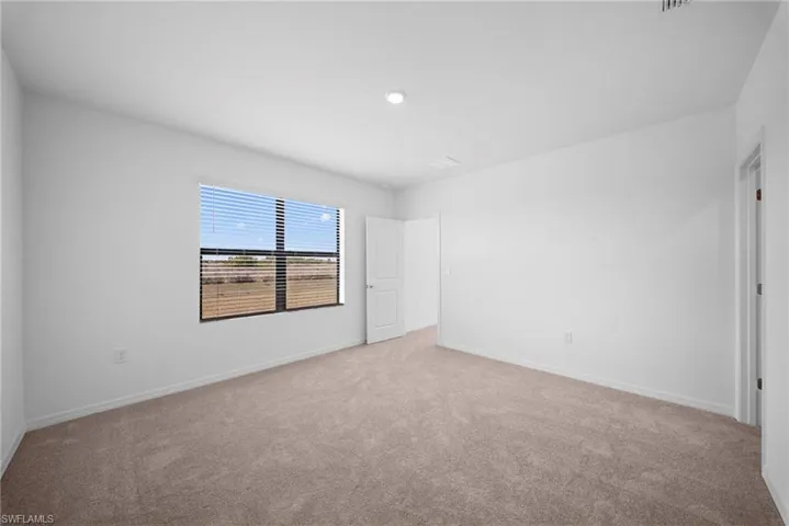 Carpeted spare room with baseboards