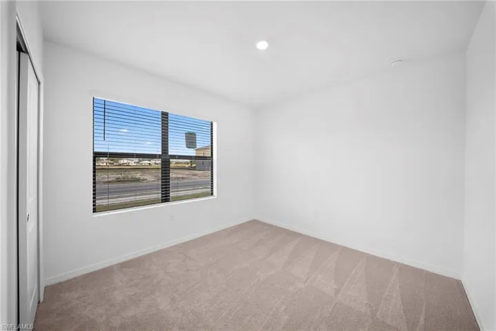 Unfurnished bedroom featuring light carpet and a closet