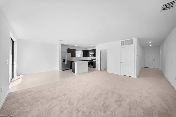 Unfurnished living room featuring light carpet and recessed lighting