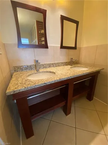 Bathroom with vanity, tile walls, and tile patterned flooring