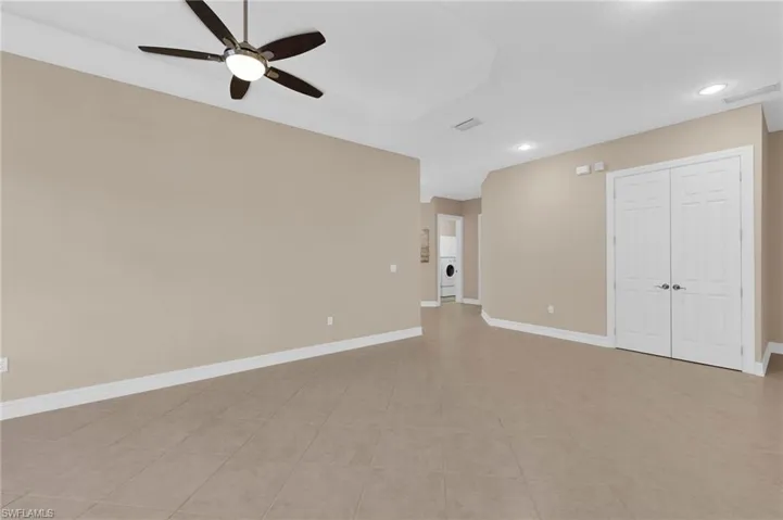 Empty room with a ceiling fan, recessed lighting, and light tile patterned flooring