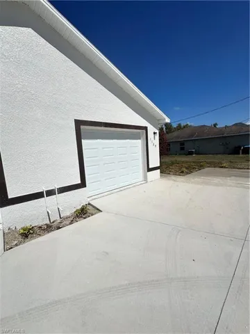 View of home's exterior featuring driveway, stucco siding, and a garage