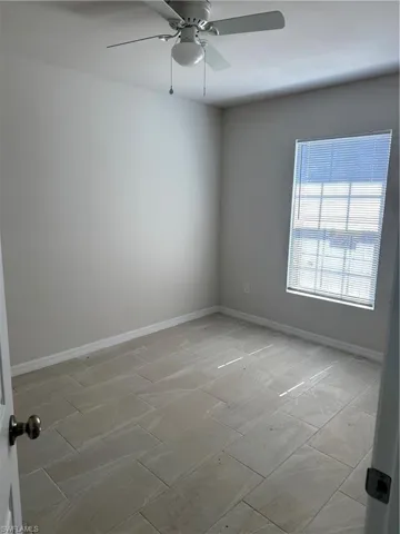 Spare room featuring baseboards and ceiling fan