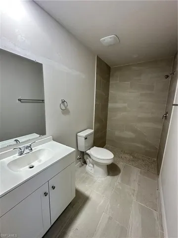 Full bath featuring vanity and a tile shower
