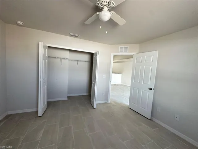 Unfurnished bedroom featuring a ceiling fan and a closet