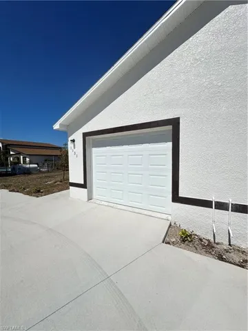 View of home's exterior featuring concrete driveway and stucco siding