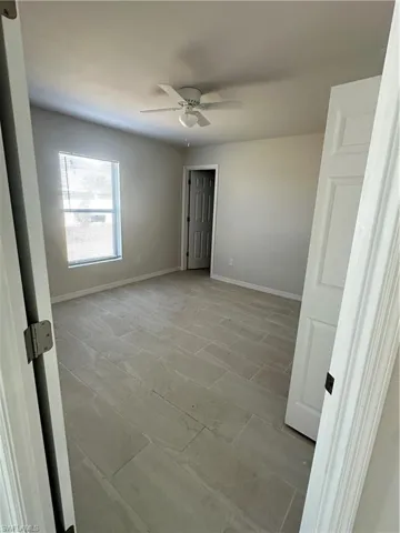 Unfurnished bedroom featuring ceiling fan and baseboards