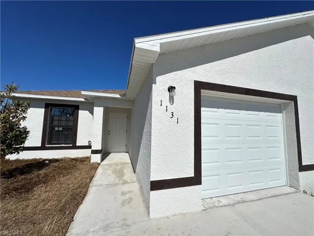 Property entrance with stucco siding and a garage