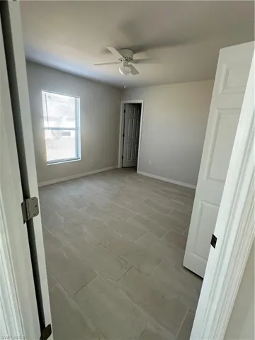 Unfurnished room with baseboards and ceiling fan