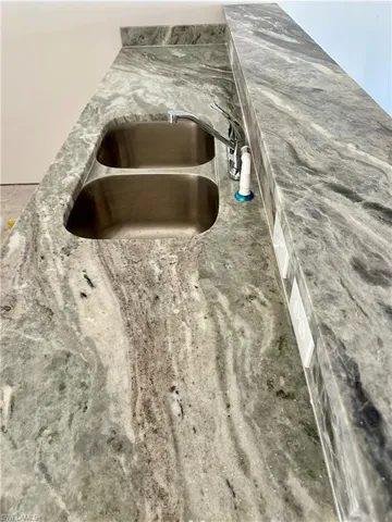 Kitchen view of a sink and light stone countertops
