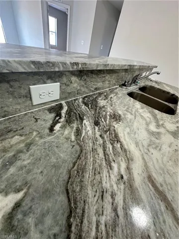 Kitchen view of a sink and light stone countertops