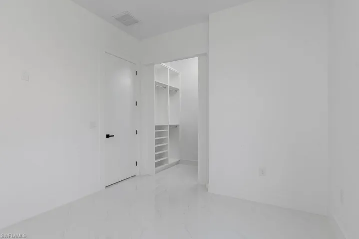 Unfurnished room with marble tiled floors and baseboards