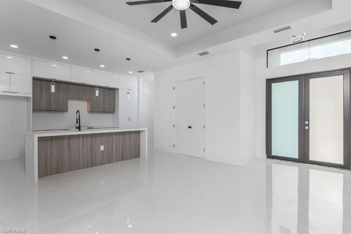 Kitchen featuring modern cabinets, ceiling fan, white cabinetry, recessed lighting, and light countertops