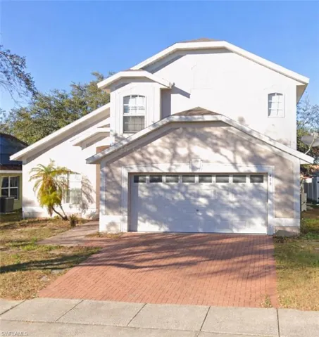 View of front of house with decorative driveway and a garage