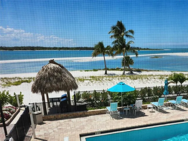 Waterside amenity area featuring a pool, paver patio, and beachfront access