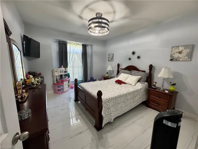 Bedroom with marble finish floor and baseboards