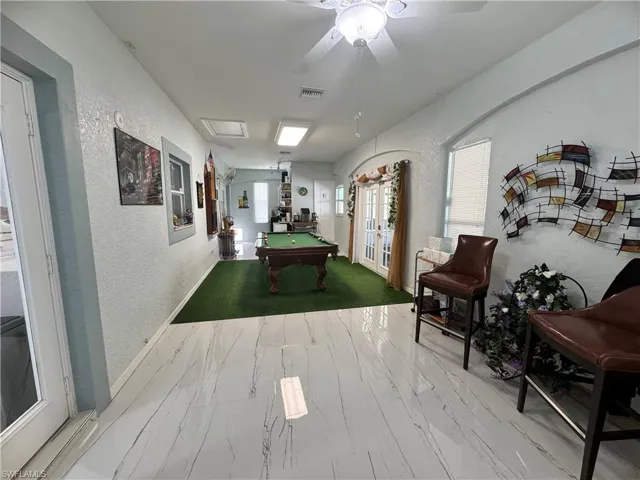 Game room with a textured wall, marble finish floor, visible vents, a ceiling fan, and pool table