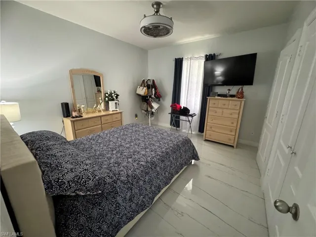 Bedroom featuring baseboards and marble finish floor
