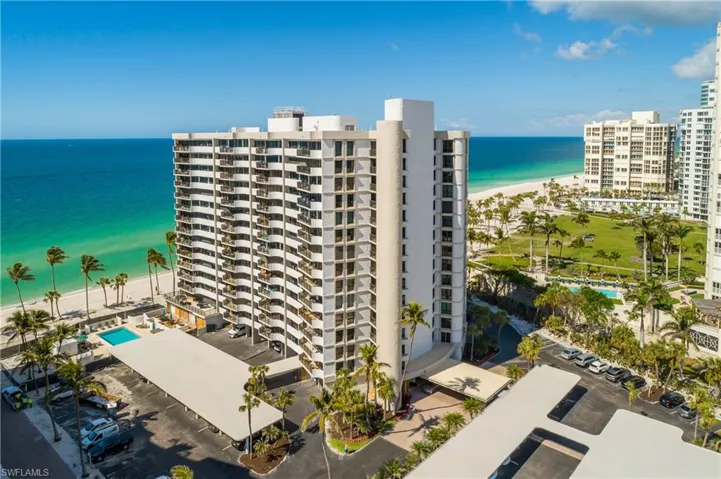 View of building exterior featuring a beach view and a water view
