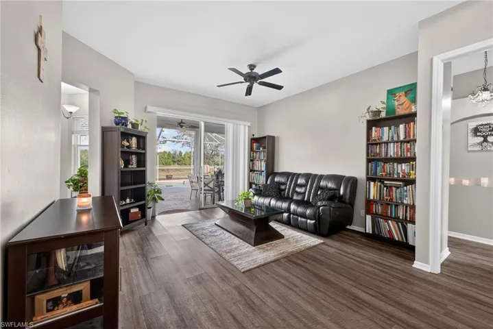 Living room with dark wood-type flooring and a ceiling fan