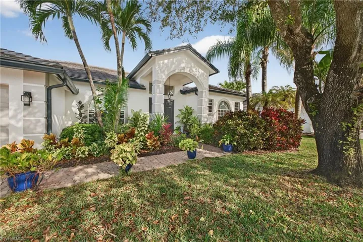 Mediterranean / spanish house with stucco siding, a front yard, and a tile roof