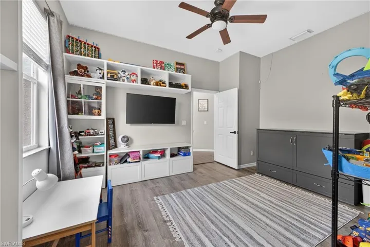 Recreation room with plenty of natural light, wood finished floors, and a ceiling fan