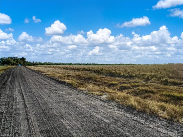 View of dirt / gravel road featuring a view of rural / pastoral area