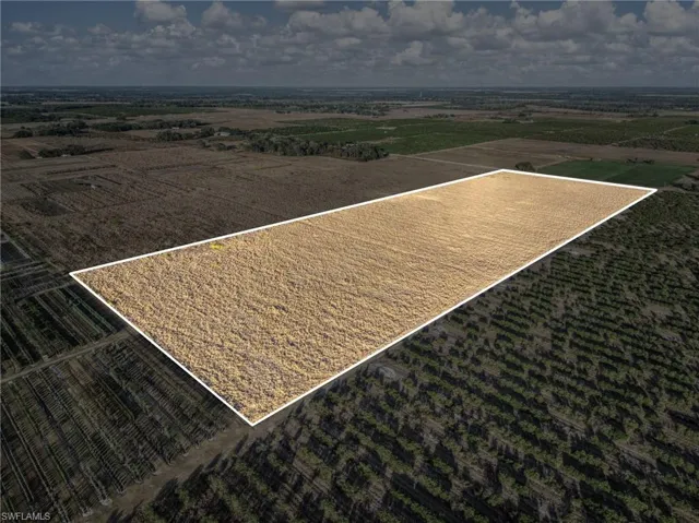 Aerial view of sparsely populated area featuring large plots for crops and property boundaries highlighted