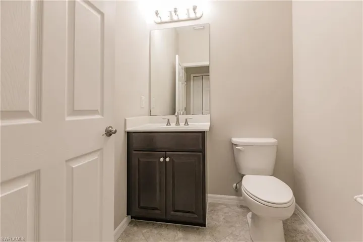 Bathroom featuring toilet, tile patterned flooring, and vanity