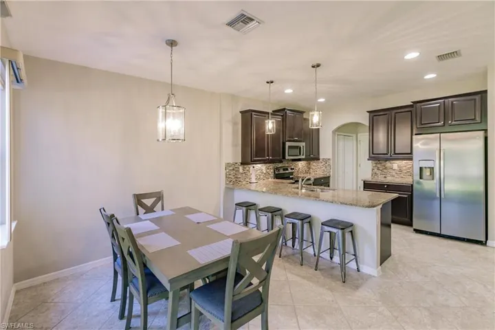 Tiled dining space with sink and an inviting chandelier
