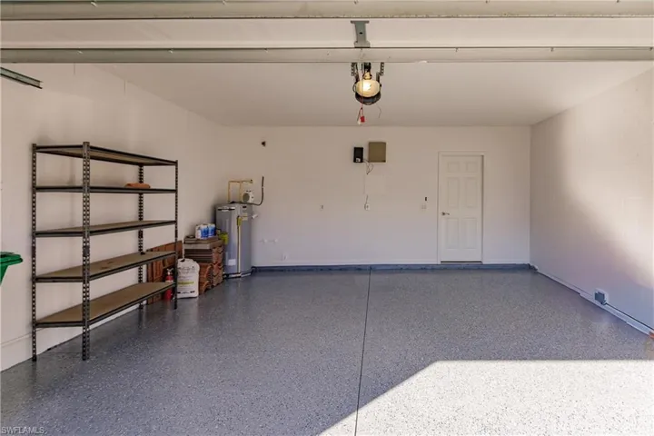 Garage featuring water heater and a garage door opener
