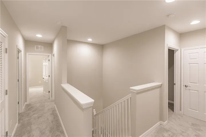 Corridor featuring light carpet