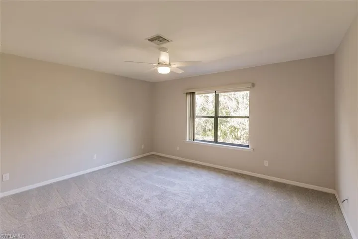 Spare room featuring ceiling fan and light carpet