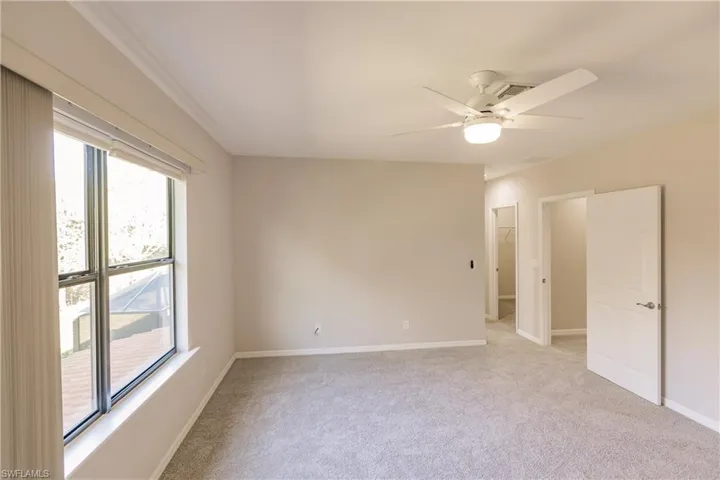 Carpeted spare room with ceiling fan