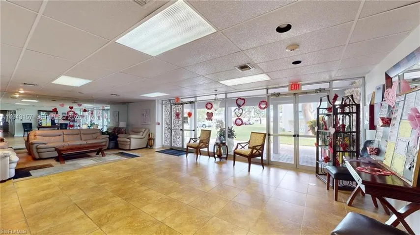 Spacious common area featuring large format tile flooring and a drop ceiling with recessed lighting
