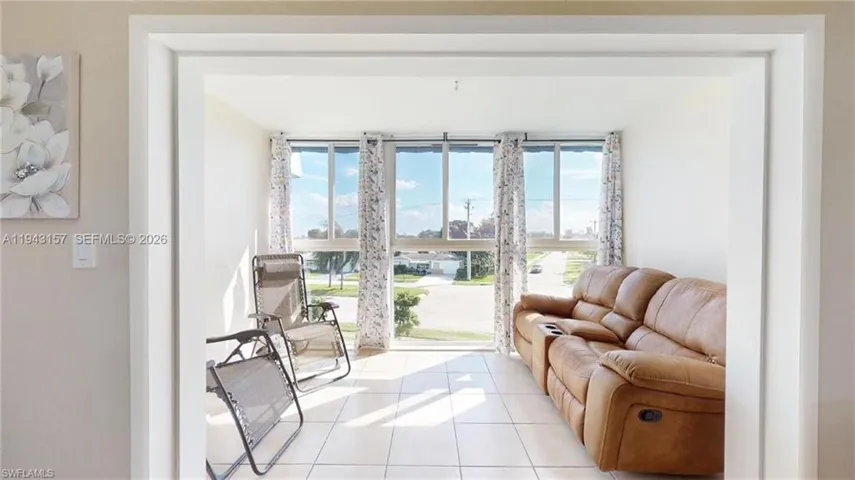 Bright interior room featuring a large window with multiple panes, providing substantial natural light