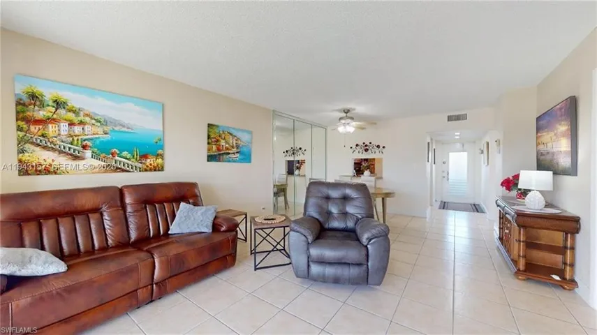 Open-concept living area featuring light-toned tile flooring throughout
