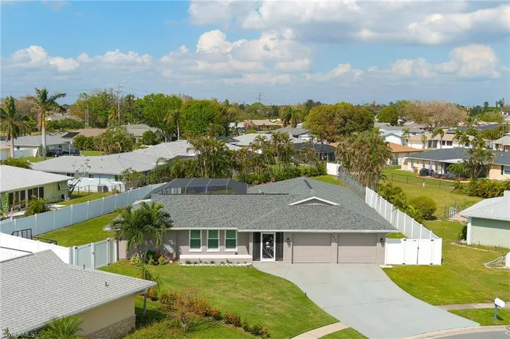 View of front facade featuring front enclosure, a garage, and a front lawn