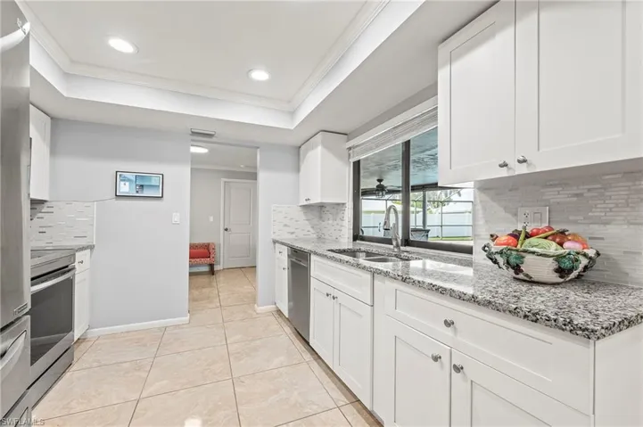 Kitchen featuring backsplash, white cabinetry, and sink