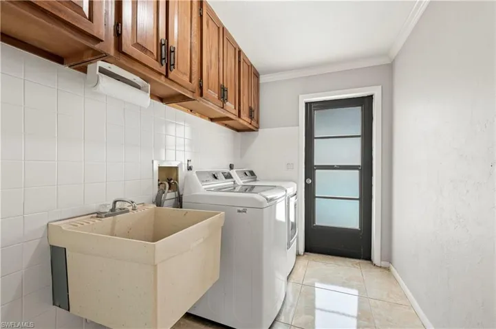 Laundry room featuring sink, and cabinets,